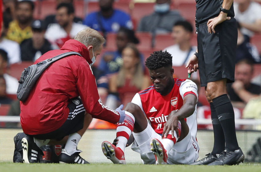 Arsenal's Ghanaian midfielder Thomas Partey receives treatment for an injury during the pre-season friendly football match between Arsenal and Chelsea at The Emirates Sadium in north London on August 1, 2021. - RESTRICTED TO EDITORIAL USE. No use with unauthorized audio, video, data, fixture lists, club/league logos or 'live' services. Online in-match use limited to 75 images, no video emulation. No use in betting, games or single club/league/player publications. (Photo by Adrian DENNIS / AFP) / RESTRICTED TO EDITORIAL USE. No use with unauthorized audio, video, data, fixture lists, club/league logos or 'live' services. Online in-match use limited to 75 images, no video emulation. No use in betting, games or single club/league/player publications. / RESTRICTED TO EDITORIAL USE. No use with unauthorized audio, video, data, fixture lists, club/league logos or 'live' services. Online in-match use limited to 75 images, no video emulation. No use in betting, games or single club/league/player publications. (Photo by ADRIAN DENNIS/AFP via Getty Images)