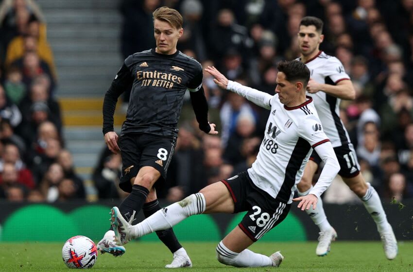 Fulham's Serbian midfielder Sasa Lukic (C) vies with Arsenal's Norwegian midfielder Martin Odegaard (L) during the English Premier League football match between Fulham and Arsenal at Craven Cottage in London on March 12, 2023. (Photo by ADRIAN DENNIS / AFP) / RESTRICTED TO EDITORIAL USE. No use with unauthorized audio, video, data, fixture lists, club/league logos or 'live' services. Online in-match use limited to 120 images. An additional 40 images may be used in extra time. No video emulation. Social media in-match use limited to 120 images. An additional 40 images may be used in extra time. No use in betting publications, games or single club/league/player publications. / (Photo by ADRIAN DENNIS/AFP via Getty Images)