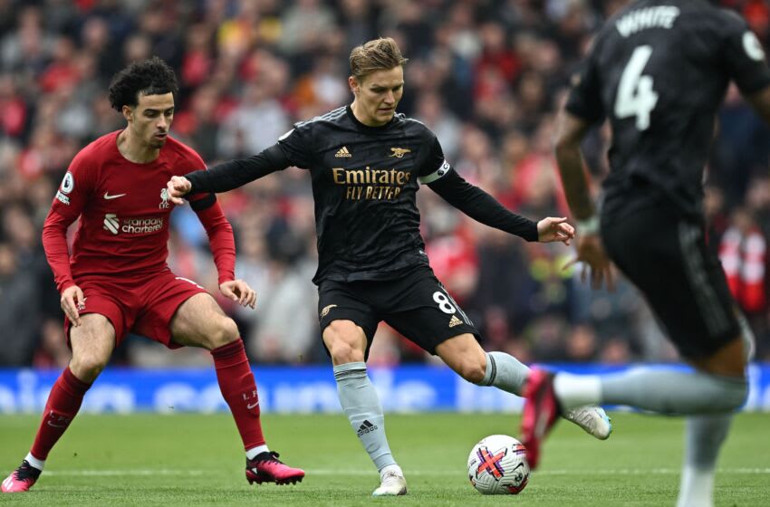 Liverpool's English midfielder Curtis Jones (L) vies with Arsenal's Norwegian midfielder Martin Odegaard during the English Premier League football match between Liverpool and Arsenal at Anfield in Liverpool, north west England on April 9, 2023. (Photo by Paul ELLIS / AFP) / RESTRICTED TO EDITORIAL USE. No use with unauthorized audio, video, data, fixture lists, club/league logos or 'live' services. Online in-match use limited to 120 images. An additional 40 images may be used in extra time. No video emulation. Social media in-match use limited to 120 images. An additional 40 images may be used in extra time. No use in betting publications, games or single club/league/player publications. / (Photo by PAUL ELLIS/AFP via Getty Images)