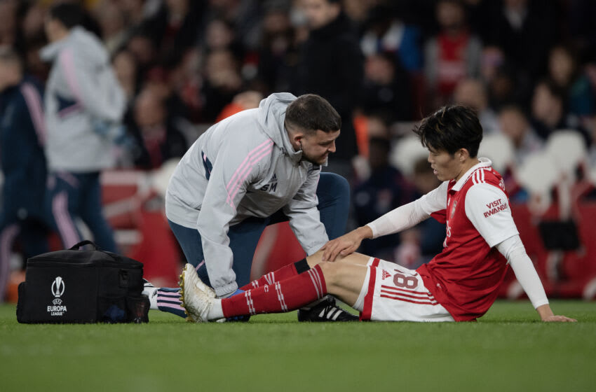 LONDON, ENGLAND - MARCH 16: Takehiro Tomiyasu receives attention from Arsenal medical staff before being substituted during the UEFA Europa League round of 16 leg two match between Arsenal FC and Sporting CP at Emirates Stadium on March 16, 2023 in London, England. (Photo by Visionhaus/Getty Images)