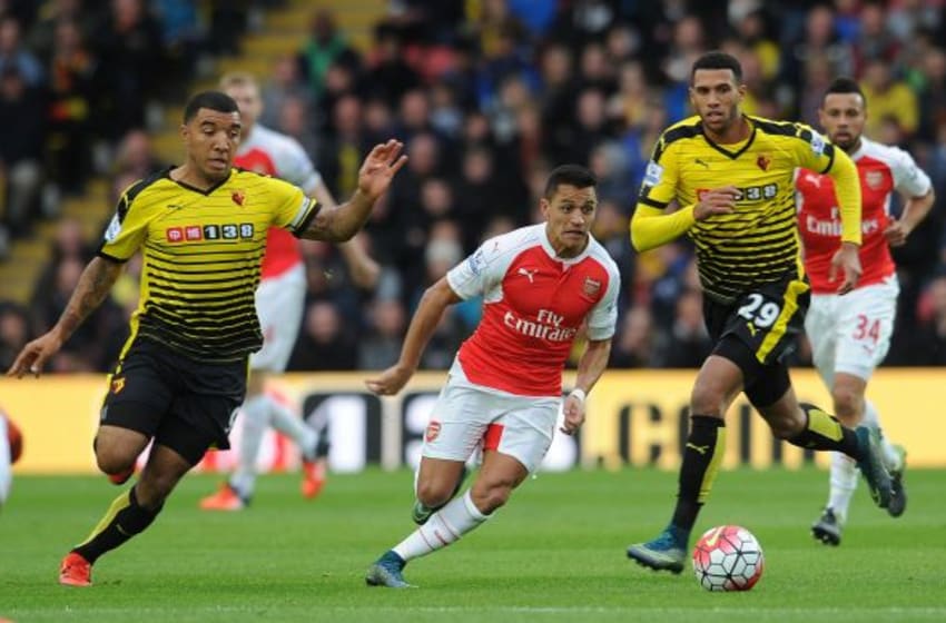 WATFORD, ENGLAND - OCTOBER 17: Alexis Sanchez of Arsenal runs at Troy Deeney and Etienne Capoue of Watford during the Barclays Premier League match between Watford and Arsenal at Vicarage Road on October 17, 2015 in Watford, England. (Photo by David Price/Arsenal FC via Getty Images)