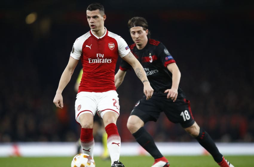 LONDON, ENGLAND - MARCH 15: Granit Xhaka of Arsenal keeps the ball from Riccardo Montolivo of AC Milan during the UEFA Europa League Round of 16 Second Leg match between Arsenal and AC Milan at Emirates Stadium on March 15, 2018 in London, England. (Photo by Julian Finney/Getty Images)